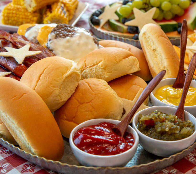Davians assorted sauces and hotdog buns on picnic table