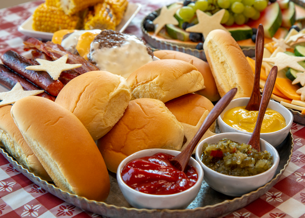 Davians assorted sauces and hotdog buns on picnic table