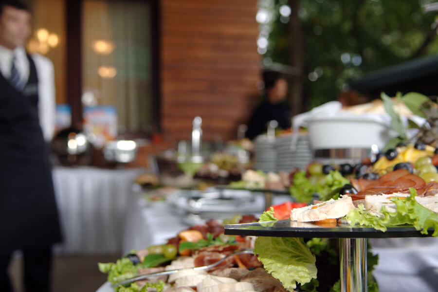 Table with food spread and waiter in background