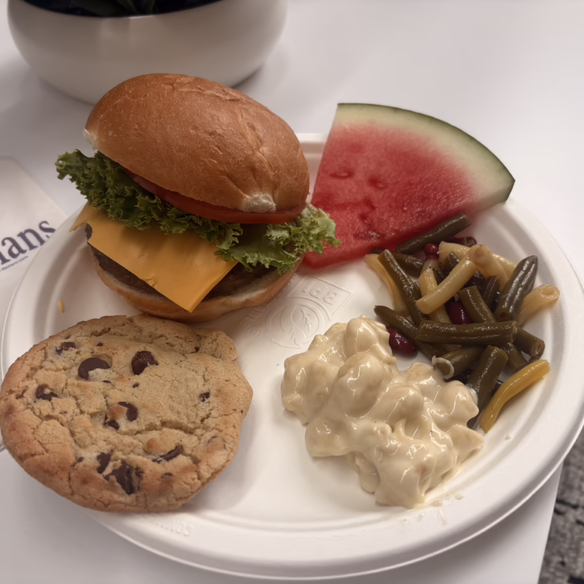Davians plate of picnic food. Burger, watermelon, green beans, mac and cheese and cookie